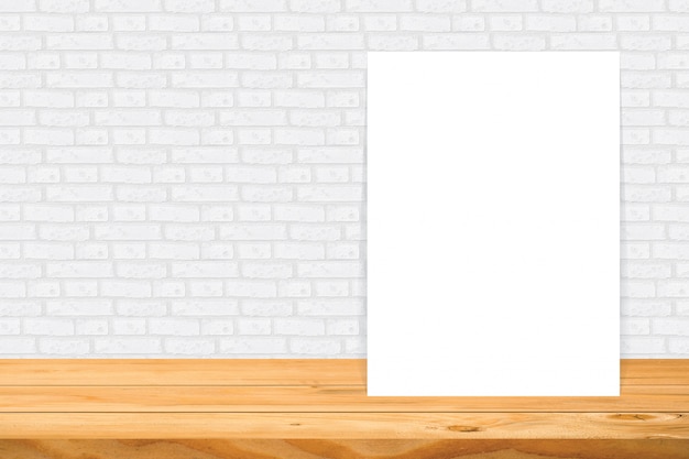 Quadro em branco na mesa de madeira na parede de azulejo branco