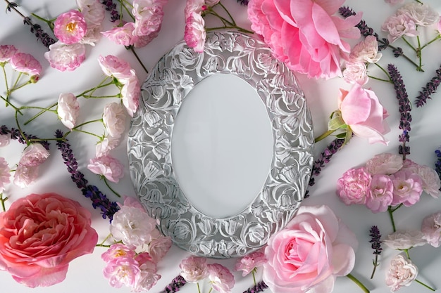 Quadro floral de flores cor de rosa em fundo branco ou rosa Vista superior plana leiga Conceito de primavera e verão Design de moldura de cabeças de rosas margaridas Espaço vazio Modelo para um cartão romântico