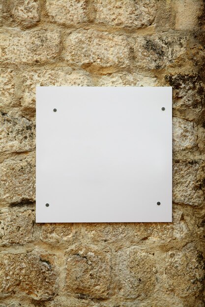 Quadro indicador branco em branco no antigo muro de pedra