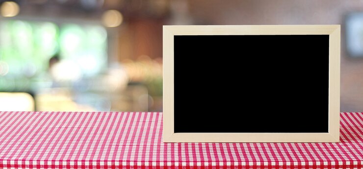 Foto quadro-negro em branco na mesa sobre a loja de borrão com fundo bokeh