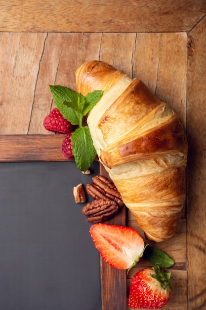 Quadro preto com croissant e bagas