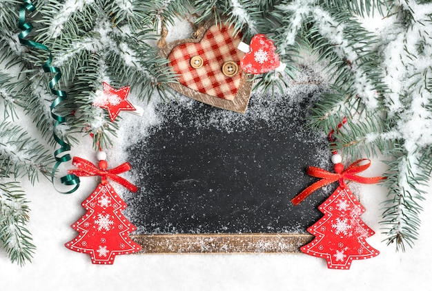 Quadro preto na neve decorada para o Natal, espaço de texto