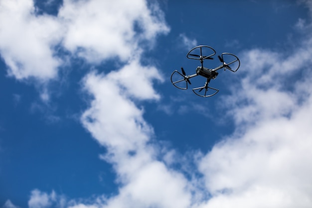 Quadrocopter contra o céu azul com nuvens brancas