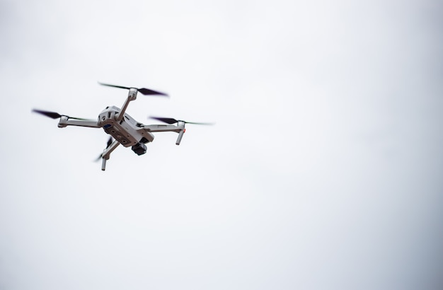 Quadrocopter drone moderno con cámara de video en el aire con el fondo del cielo
