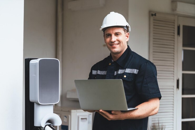 Foto qualifizierter techniker, der mit einem laptop für die heim-ev-station synchronos arbeitet