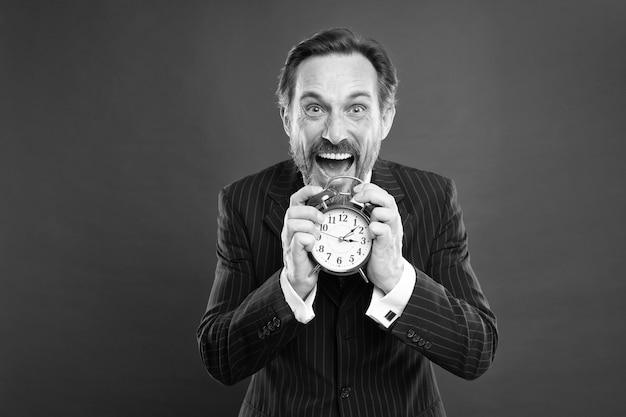 Quanto tempo resta até o prazo Gerente com despertador Homem barbudo empresário segurar relógio Homem maduro barba pronta começar a trabalhar Hora de trabalhar Empresário se preocupa com o tempo Habilidades de gerenciamento de tempo