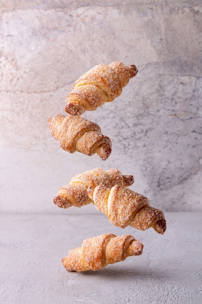 Quark-Mini-Croissants fliegen auf Vintage-Papierhintergrund