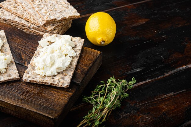 Quark-Sandwiches mit frischen Kräutern. Knäckebrot-Toast mit Hüttenkäse-Set, auf alten dunklen Holztisch