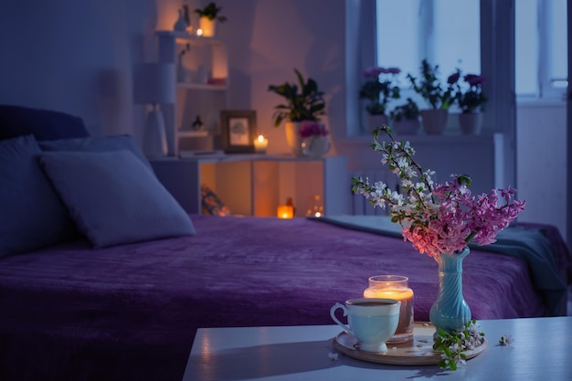 Quarto aconchegante à noite com flores e chá