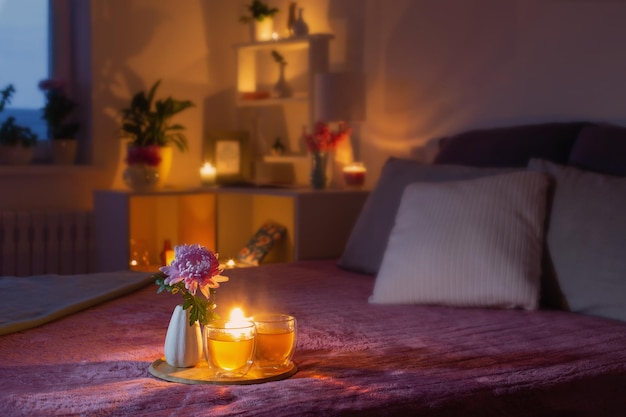 Quarto aconchegante à noite com flores e chá