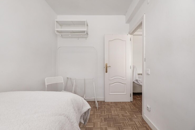 Foto quarto com cama de solteiro com piso em parquet de ripas xadrez guarda-roupa tipo burro prateleiras altas