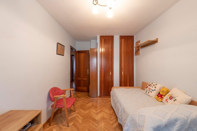 Foto quarto com uma cama de jovem com roupeiros embutidos e soalho em parquet de carvalho espinha de peixe