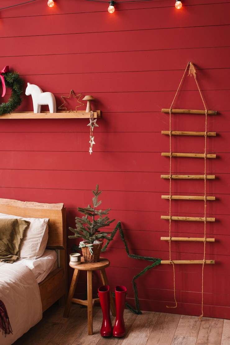 Foto quarto de dormir vermelho com uma árvore de natal e uma coroa de flores na parede