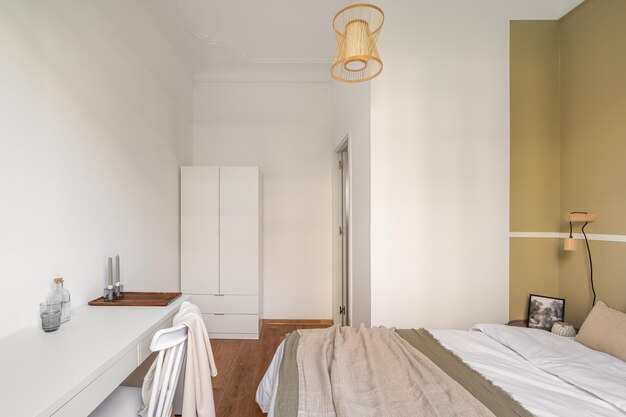 Quarto de hotel aconchegante em tons beige claro com uma cama de casal e uma mesa com uma cadeira confortável e