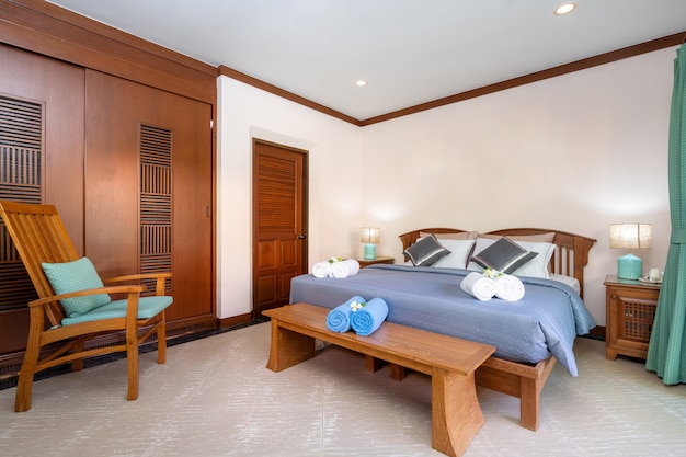 Foto quarto espaçoso com lençol azul e lençol de madeira