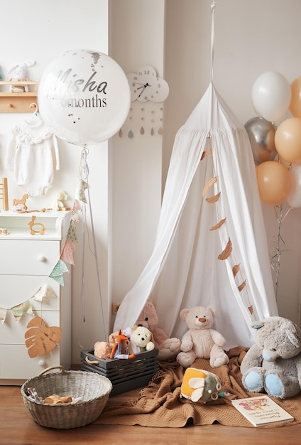 Quarto infantil interior branco estilo escandinavo, quarto, berçário. berço com dossel. prateleiras e brinquedos de madeira. barraca de dossel, pipa têxtil e balões.