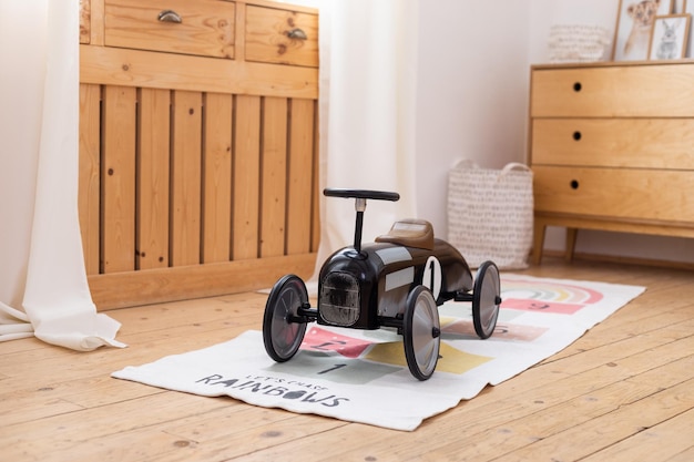 Foto quarto infantil moderno com interior em estilo retrô escandinavo de carro de brinquedo vintage