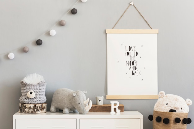 Quarto infantil scandi elegante com moldura de madeira para fotos, brinquedos de pelúcia e madeira, caixas, blocos e acessórios. Padrão de estrelas na parede do fundo. Interior luminoso e ensolarado. Decoração de casa.