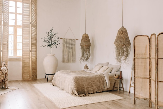 Quarto luminoso espaçoso com paredes brancas e uma cama grande em tons quentes de boho