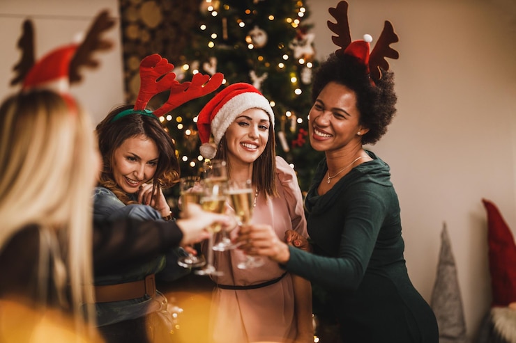 Foto quatro alegres garotas multiétnicas se divertindo enquanto brindam com champanhe na festa em casa de natal ou ano novo.