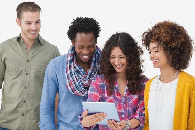 Foto quatro amigos elegantes que procuram tablet