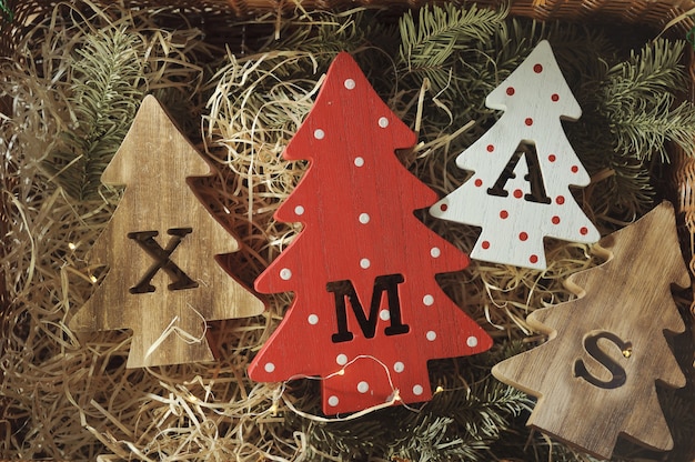 Quatro árvores de Natal decorativas de madeira com letras esculpidas e enfeites de natal