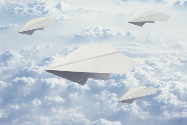 Foto quatro avião de papel voando no céu azul e clound