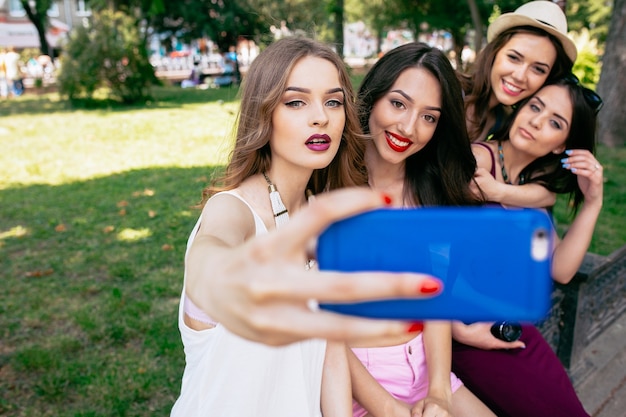 Quatro belas jovens fazendo selfie no parque