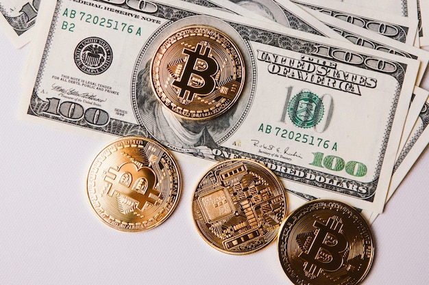 Foto quatro bitcoins e um pacote de dólares