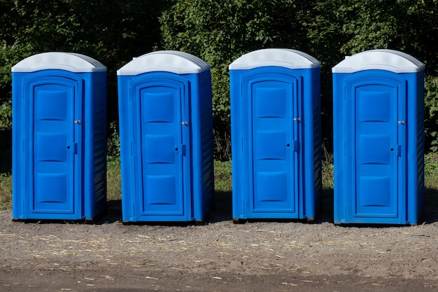 Quatro box de banheiro portátil de plástico azul no parque