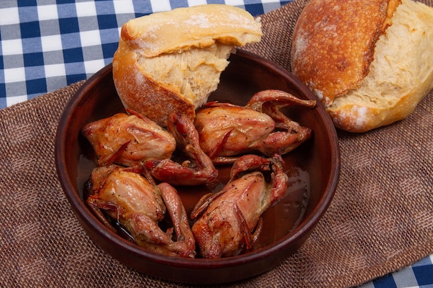 Quatro codornas assadas e dois pedaços de pão branco Rústico