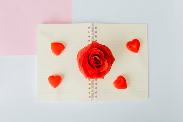 Quatro doces de amor e uma rosa colocados no caderno