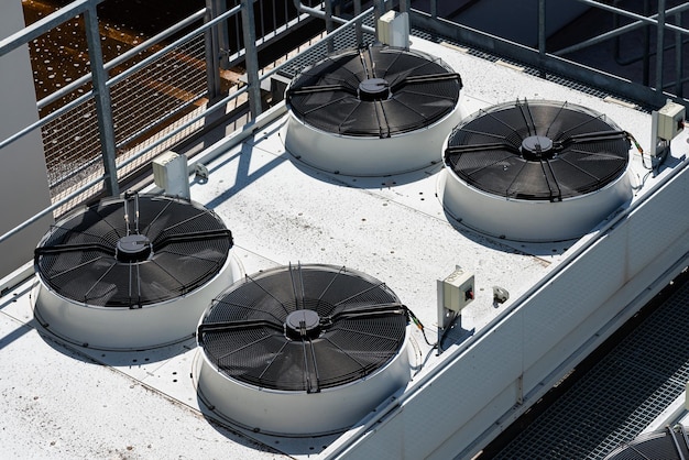 Quatro grandes ventiladores industriais no telhado do edifício de produção