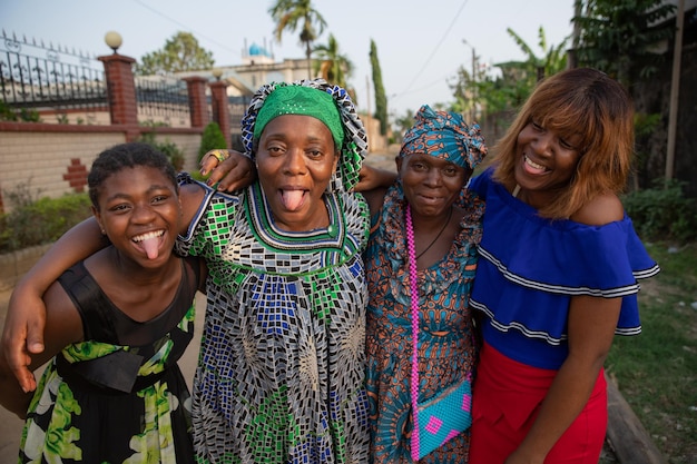 Quatro mulheres africanas de diferentes idades riem juntas e fazem caretas