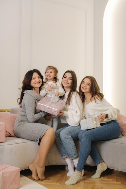 Quatro mulheres de diferentes idades na época do Natal, da neta à avó, presentes no