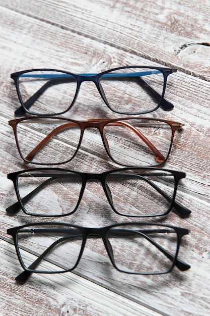 Foto quatro pares de óculos em uma luz de madeira