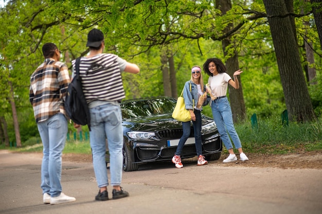 Quatro pessoas na floresta perto do carro preto