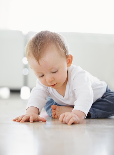 ¿Qué es esta foto de un lindo bebé jugando mientras está sentado en el suelo?