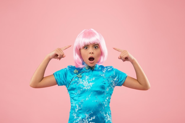 ¿Qué está pasando? Peluquería Moda y belleza niña sorprendida señalando la peluca Niño fiestero en estilo chino pequeña niña china en peluca rosa niño en vestido tradicional chino niña china retro