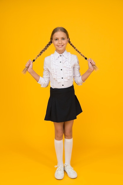 Qué gran día, una niña pequeña lista para estudiar educación de regreso a la escuela en línea, mientras que una alumna alegre en cuarentena tiene un elegante día de conocimiento del cabello, desarrollo infantil, niña de la escuela, usa uniforme