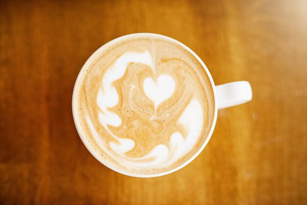 Qué hermosa toma de ángulo alto de una taza de café en una mesa en una cafetería