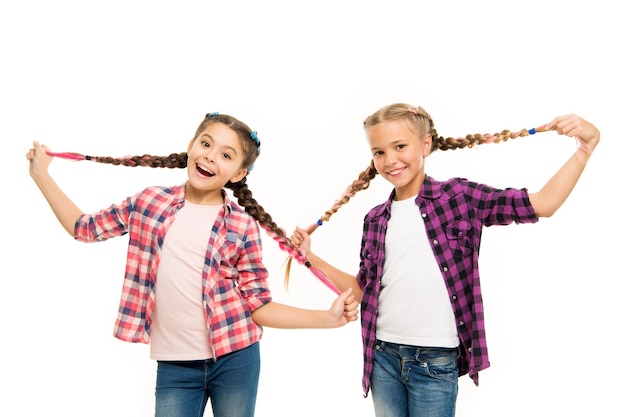 Qué pelo tan largo. Las niñas felices llevan el pelo trenzado. Lindas trenzas de pelo para niños pequeños. Extensiones de cabello de lujo. Peluquería para niños.