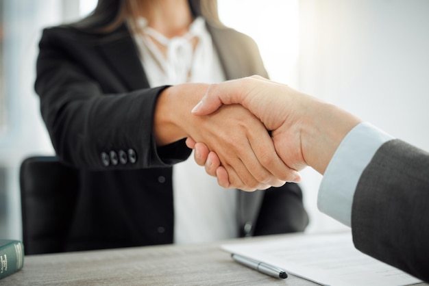 ¿Qué puedo hacer para ayudar? Toma de dos abogados dándose la mano a modo de saludo.