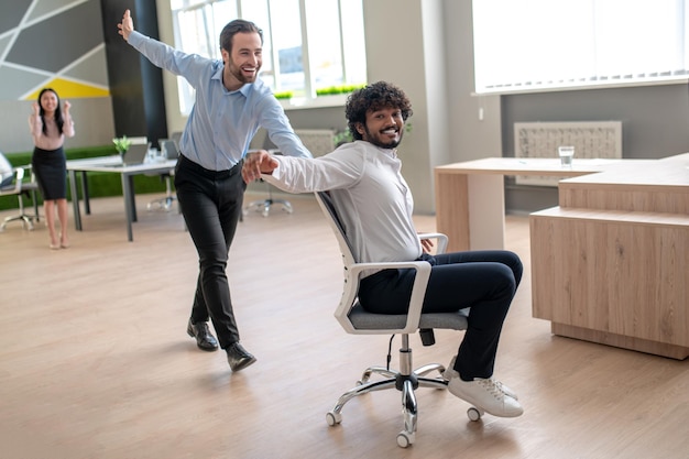 Foto que te diviertas. jóvenes colegas divirtiéndose en la oficina después del trabajo