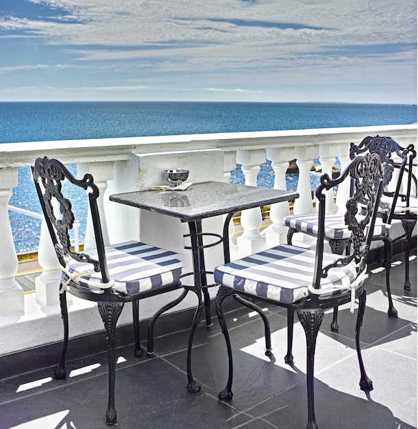 Qué vista Mesas y sillas en el balcón de un restaurante junto al mar