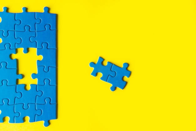 Quebra-cabeça azul sobre fundo amarelo, conexão de negócios, conceito de sucesso e estratégia, trabalho em equipe