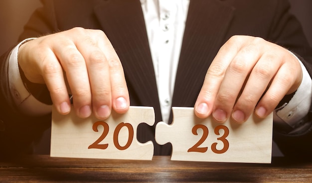 Quebra-cabeças de madeira com a inscrição 2023 Estabelecendo metas e objetivos para o novo ano Planejando o conceito de gestão e estratégia de negócios Tendências e ideias Visão