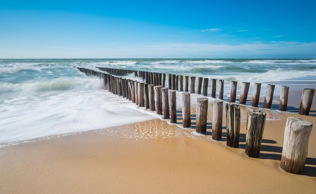 Quebra-mar em uma praia arenosa em Zeeland Holanda