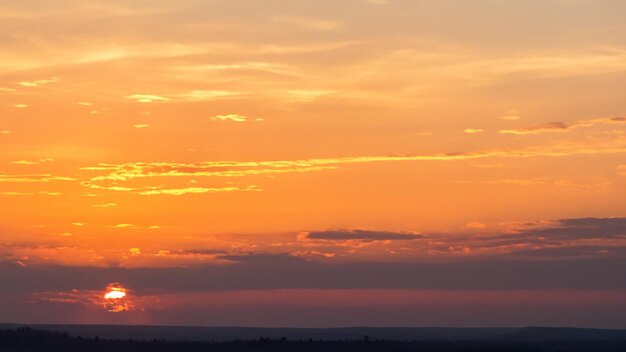 Quebrando o horizonte do nascer do sol noturno e a paisagem nublada