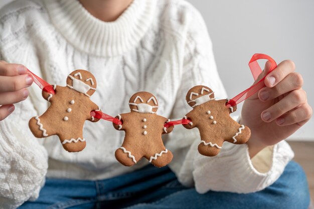 Quédate en casa en cuarentena del Covid-19. Hombres de pan de jengibre de Navidad con máscaras